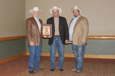 Wagonhound Land and Livestock was honored as the 2015 Commercial Producer of the Year at the Red Angus Association of America National Convention. Craig Bieber, pictured far right, presented the award to Art Nicholas and Dustin Ewing. 